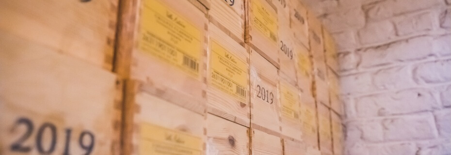 Réserve de vins entreposés dans des caisses datées.